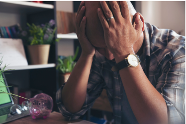 A man with his head in his hands in a defeated gesture.